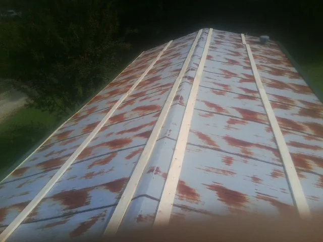 Rusted metal roof panels with new wood purlins before replacement — Storm Damage Roof Repair in Big Lake by Roofing Brothers