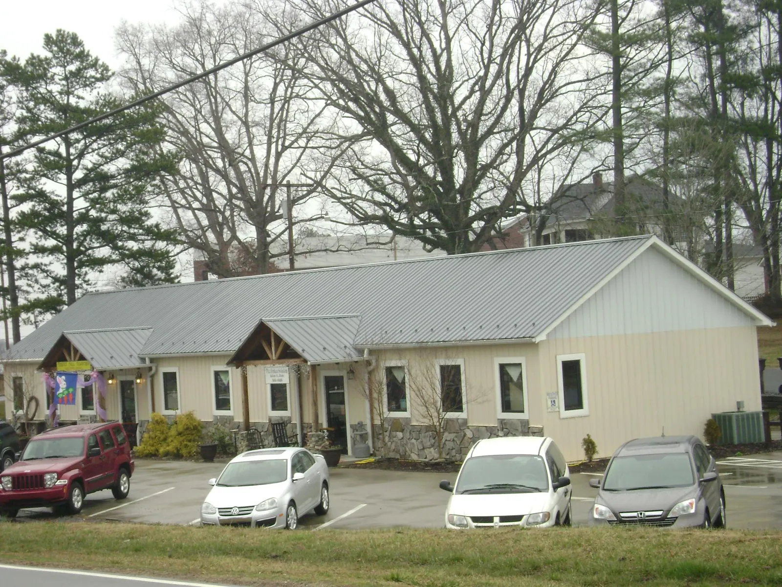 Gray metal roof with timber entry brackets on a small commercial building in Big Lake