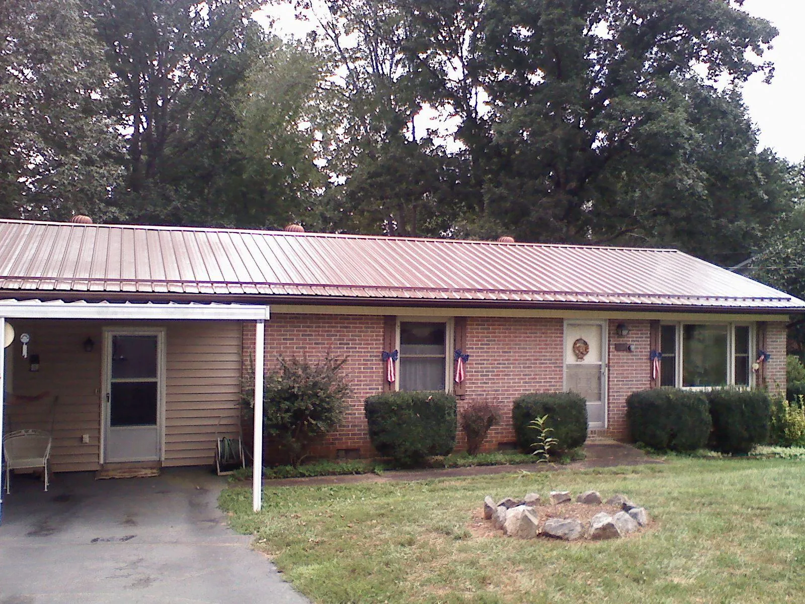 Bronze metal roof and carport on a brick ranch home — Roof Repair work by our crew in Big Lake