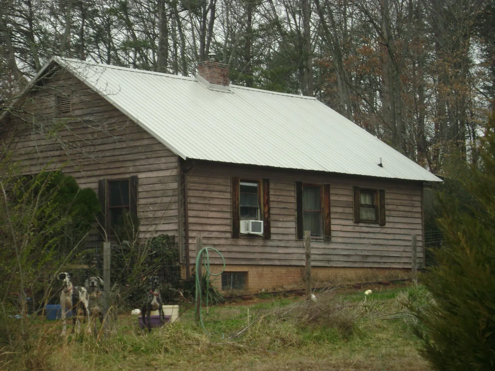 White metal roof on an old wood sided farmhouse, from a Metal Roof Installation job in Big Lake